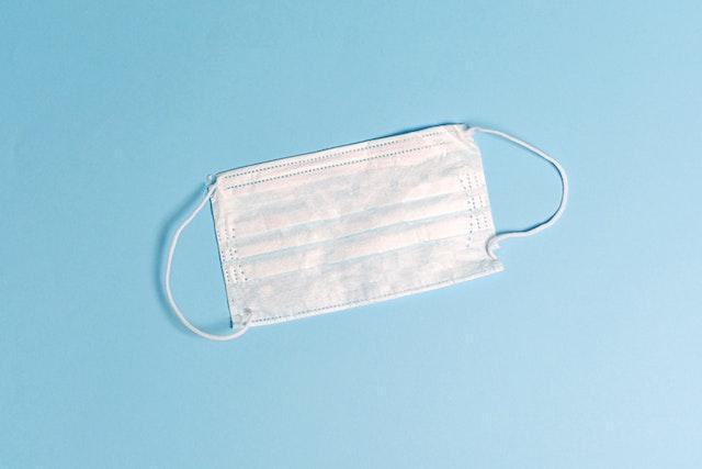 水色を背景に置かれた不織布マスク
