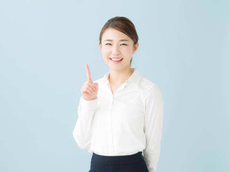笑顔で人差し指を立てる女性