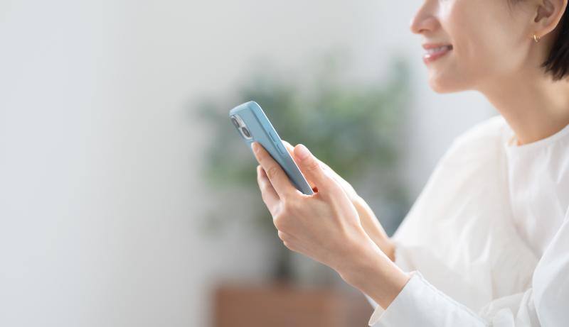 スマートフォンを手にした笑顔の女性