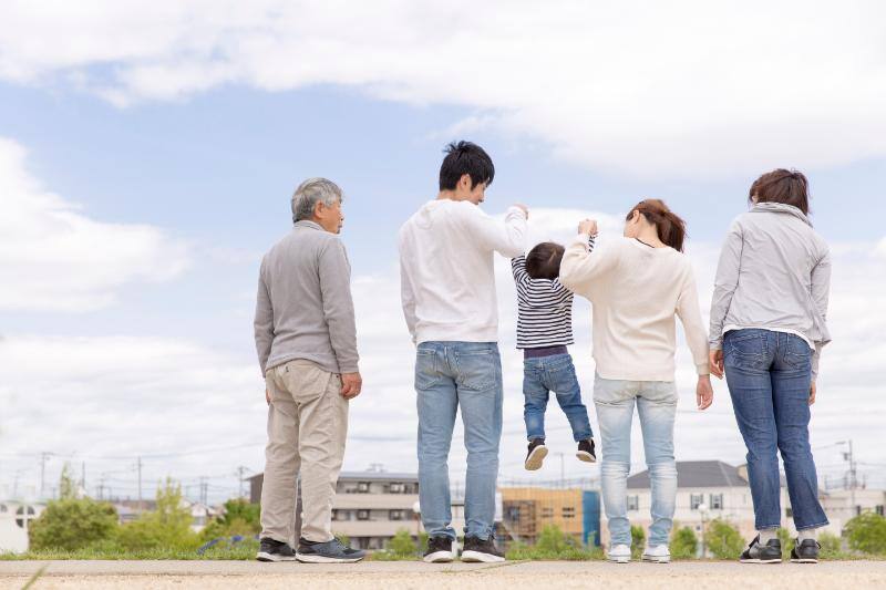 街を背景に立つ家族の後ろ姿