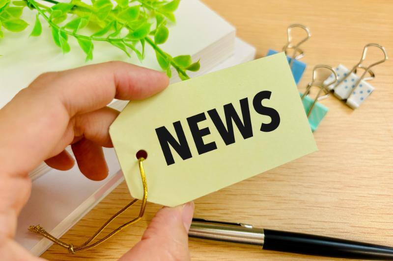 「NEWS」と書かれたタグを持つ手