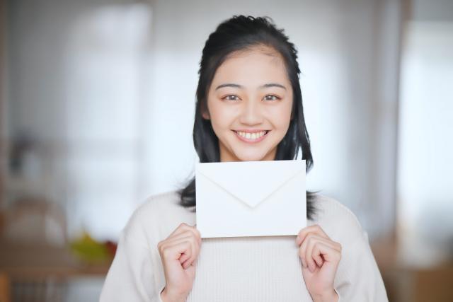 笑顔で手紙を掲げている女性