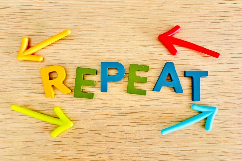 机上に並べられた立体の「REPEAT」のアルファベットと矢印